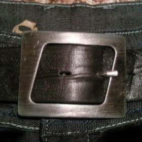 Černý kožený pásek s velkou stříbrnou přezkou