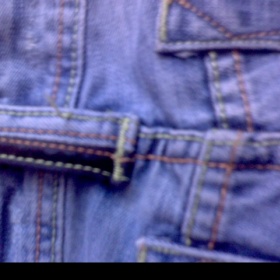 Stětle modré džíny s dírami a kůží