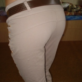 Béžové kalhoty s mírně spadlým sedem a cvoky ve zlatě