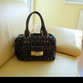 Černá kabelka Guess se šedými logy a bronzovým kováním